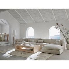 a living room filled with lots of furniture next to large windows and a rug on the floor