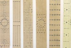 five different types of rulers lined up on a white surface with lines drawn across them