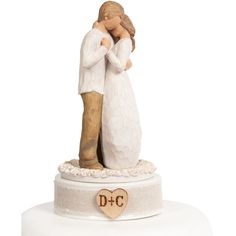 a wedding cake topper with a bride and groom figurine on the base