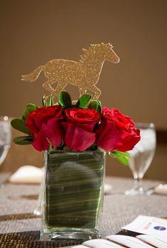 a vase filled with red roses on top of a table