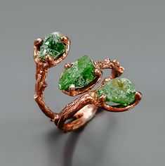 This ring features three amazing raw emerald gemstones in bright green color. Handcrafted with great details in rose gold colors. Charming, isn't it? ♥ The design can be made with gemstones of your choosing ♥ Each order will be gift wrapped beautifully ♥ QUALITY: Each item is stamped according to US regulations.  ------   *DIMENSIONS*  ------ ♥ Ring Size: 7.5 US as you see it on the picture. It could be easily adjustable according to your finger, just squeeze it a little or open.  Main Metal: 92 Handmade Green Emerald Ring, Nature-inspired, Green Three Stone Ring Jewelry, Handmade Nature-inspired Green Emerald Ring, Nature-inspired Green Jewelry With Raw Stone, Green Raw Stone Jewelry For May Birthstone, Unique Green Crystal Promise Ring, Unique Green Jewelry With Raw Stone, Nature-inspired Emerald Ring For May Birthstone, Nature-inspired Green Emerald Gemstone Ring