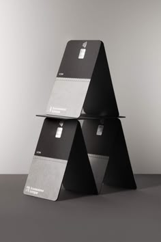 three black and white business cards stacked on top of each other in the shape of a pyramid