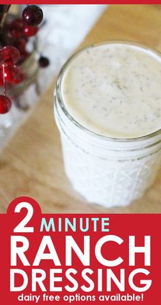 two mason jars filled with ranch dressing on top of a wooden table next to red berries