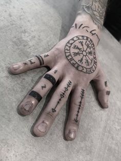 a person's hand with tattoos on it