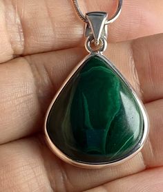 An elegant and high quality (AAA) Malachite and silver pendant including the chain. This stone is a good size and is of a beautifully refreshing green colour. Malachite is an important protection stone and this piece  is pear-cut and set in a fine detailed silver setting. This decorate setting adds complexity and flair to the piece.  This pendant measure - 2.5cm long x 2.4cm wide x 0.7cm deep (measurements do not include the bail). Pendant weight - 10 grams. Clients can select the following purc Green Polished Sterling Silver Gemstones, Green Sterling Silver Gemstones With Polished Finish, Silver Malachite Pendant Necklace, Silver Malachite Gemstone Necklace, Green Polished Pendant Necklace, Green Gemstone Drop Necklaces, Green Gemstone Drop Necklace, Green Pendant Necklace With Polished Finish, Silver Drop Necklace With Emerald