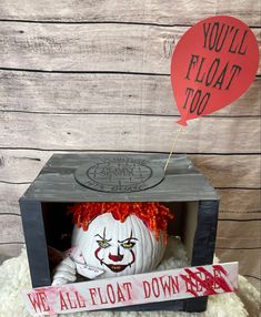 a scary looking pumpkin in a box with a sign that says you'll float too