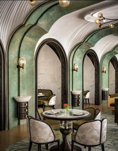 an elegant dining room with green walls and arches