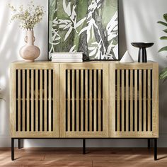 a wooden sideboard sitting on top of a hard wood floor next to a plant