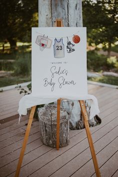 an easel with a sign that says welcome to the baby shower and basketballs on it