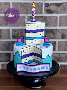 a birthday cake with a candle on it sitting on top of a black plate in front of a brick wall