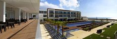 an outdoor dining area with tables and chairs next to a swimming pool on the beach