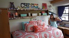 a woman standing next to a bed in a bedroom