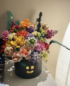 a vase filled with colorful flowers on top of a table next to a cell phone