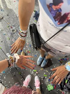 several people standing around each other with their hands in the air and confetti all over them