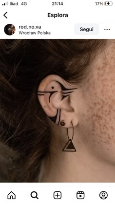 a woman with ear piercings on her ears and behind her ear is an image of a bird