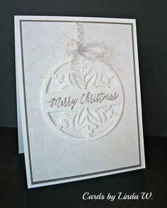 a white christmas card with an ornament on it