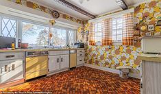 an old fashioned kitchen with yellow and orange wallpaper