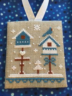 a cross stitch ornament hanging on a blue background