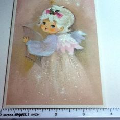 a little angel is holding a book in her hands and wearing a pink dress with sequins on it