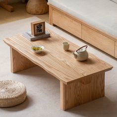 a wooden table sitting on top of a white carpeted floor next to a bed