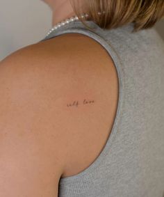 the back of a woman's shoulder with an inscription on it that says, we are