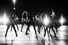 black and white photograph of dancers in front of bright spotlights on the dance floor