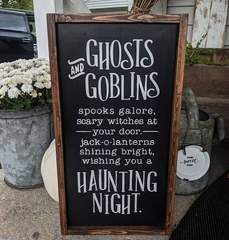 a sign that says ghost's and gobblings in front of some potted plants