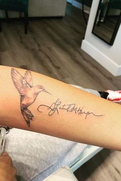 a woman's arm with a bird tattoo on it and the word, elizabeth written in cursive writing