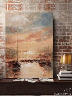 a painting is hanging on the wall next to a lamp and bookshelf in front of a brick wall