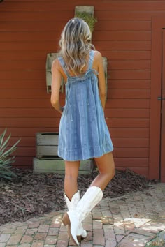 Mini denim dress. Medium wash. Square neckline. Thick tank straps secured with bow detailing in the back. Material: 90% Cotton, 10% Viscose. Sizing: Small: US Size 0-2 Medium: US Size 4-6 Large: US Size 8-10 Model Measurements: Height: 5’11” Chest: 32” Waist: 26” Hips: 36” Wearing size small. Denim Vest With Dress, Cowgirl Dress To Impress, Country Girl Outfits Summer, Country Dance Outfit, Barn Dance Outfit, Denim Dress Outfit Ideas, Dress With Cowgirl Boots, Western Summer Outfits, Denim Tank Dress