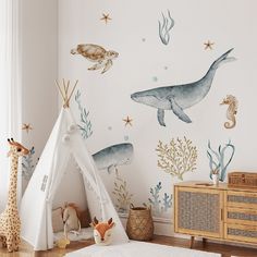 a child's room with a teepee tent and sea animals on the wall