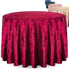 a round table covered in pink and white crushed velvets with three different color tables behind it