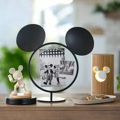 a mickey mouse head is shown on top of a table next to a lamp and figurine