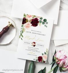 the wedding stationery is surrounded by flowers