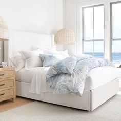 a white bed sitting next to a window in a bedroom