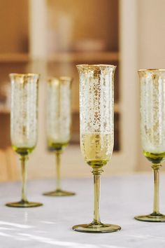 four champagne glasses lined up on a table