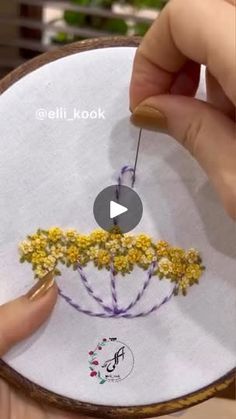 a person is stitching flowers on a hoop