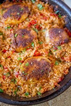 a skillet filled with rice and meat on top of a table