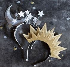 a paper crown with stars and moon on it's side, next to a crescent