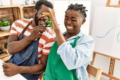 two people sitting at a table with scissors in their hands