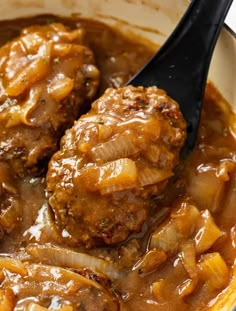 two meatballs covered in gravy with onions and carrots