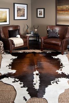 a living room with two chairs and a cowhide rug