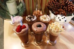 there are many desserts on the table with chocolate milkshakes and ice cream