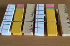 four wooden clothes pins lined up next to each other on top of a wood table