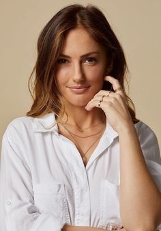 a woman wearing a white shirt is posing for the camera