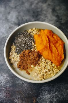 a white bowl filled with different types of food on top of a stone countertop