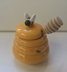 a ceramic honey pot with a bee on top