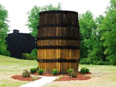 a large wooden barrel sitting in the middle of a field