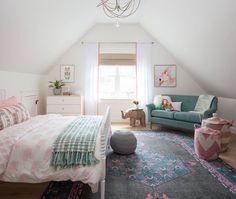 a bedroom with a bed, couch and rug in it's corner area next to a window