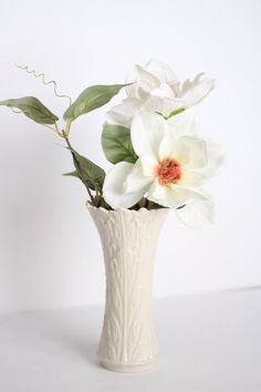 there is a white vase with flowers in it